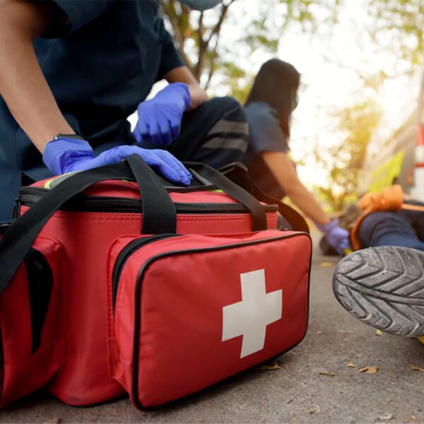 Paramedics assisting an injured person roadside.