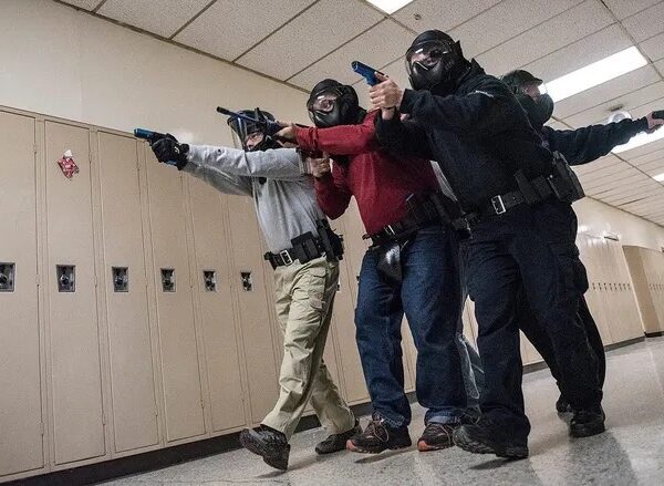 Police officers in training exercise with guns.