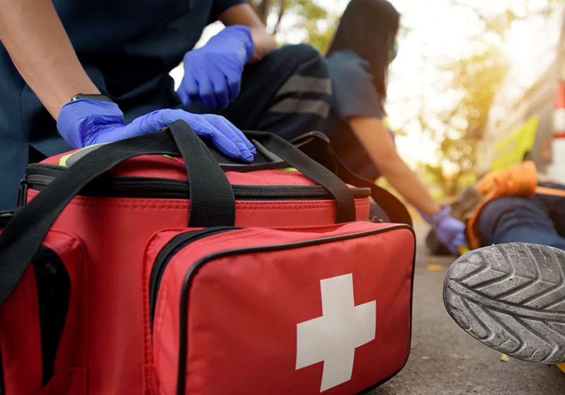 Paramedics assisting an injured person roadside.