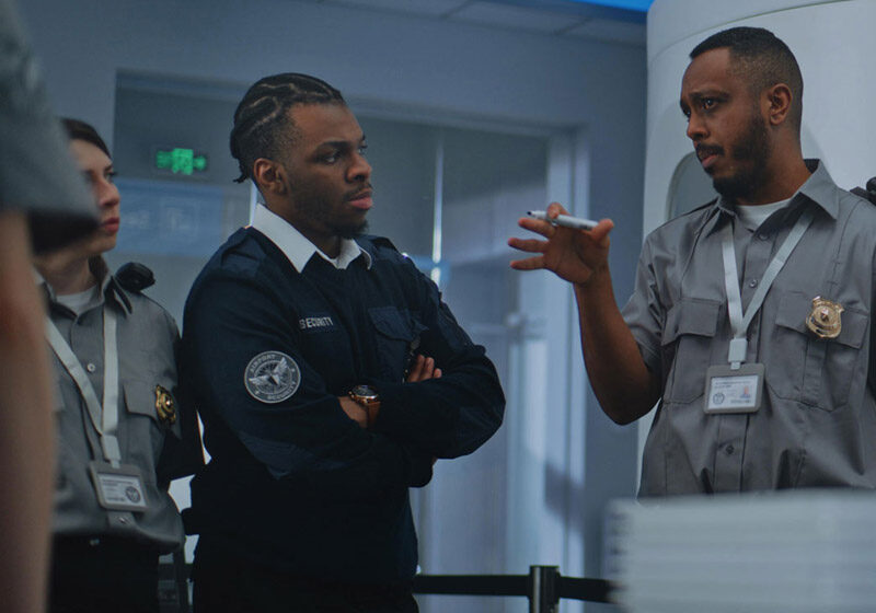 Security staff discussing at checkpoint area.
