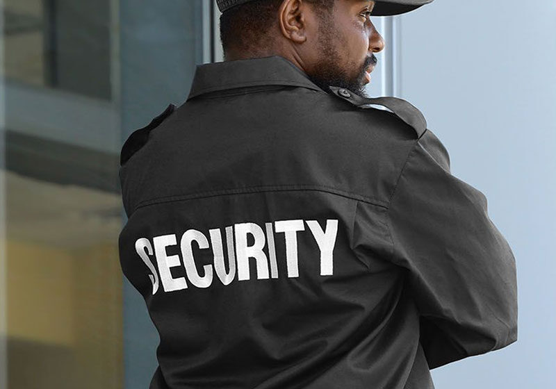 Security guard standing outside a building.