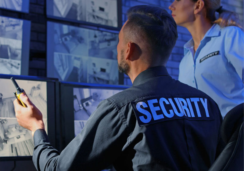 Security personnel monitoring surveillance camera screens.